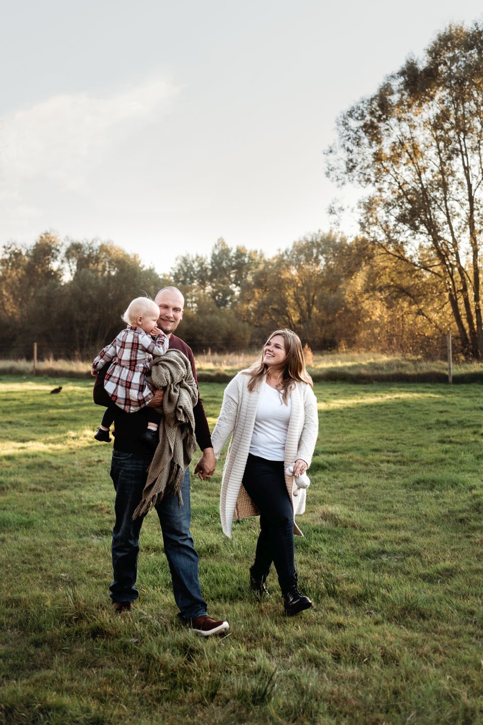 Rodina s malou dcerou spolu kráčí po louce.