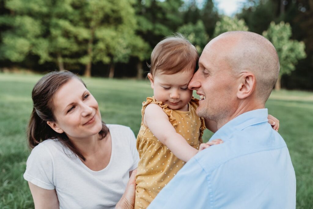Dcera se mazlí s tatínkem na louce.