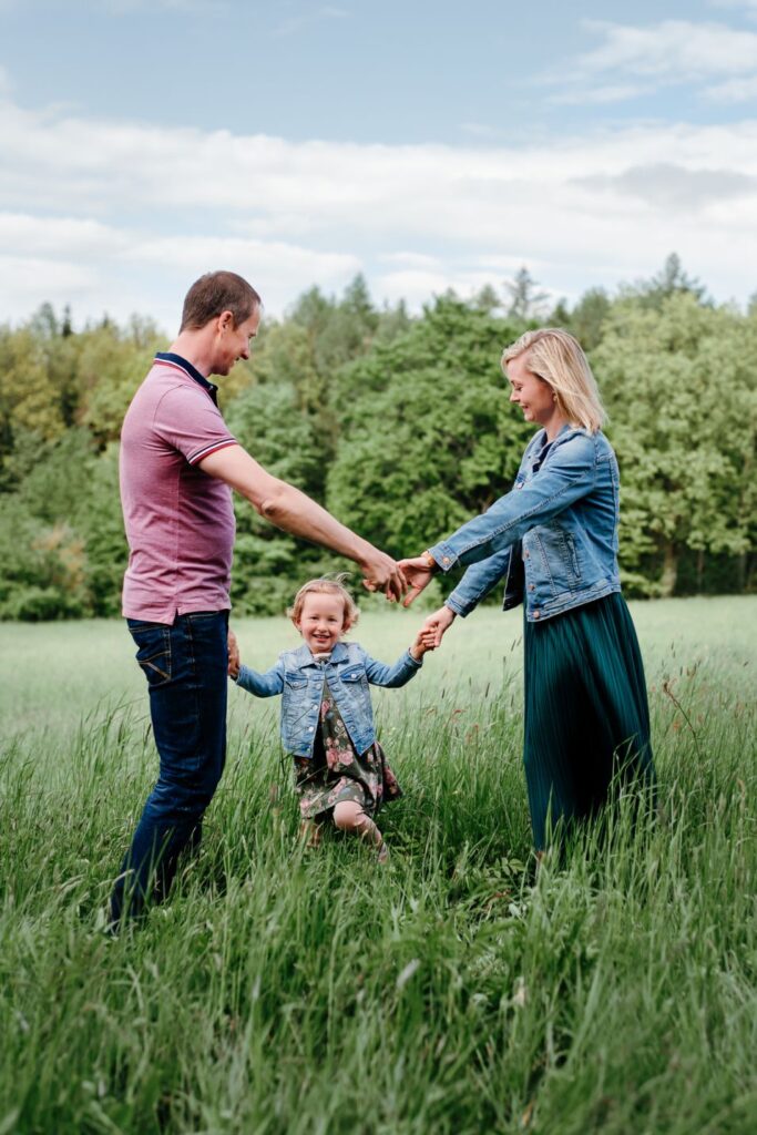 Rodina s dcerkou na louce tančí kolo kolo mlýnské.